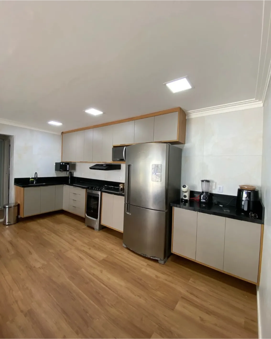 Cozinha planejada com armários claros e bancada moderna